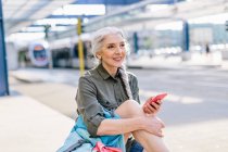 Женщина-турист держит смартфон — стоковое фото