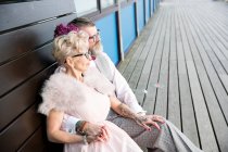 Paar sitzt auf Seebank — Stockfoto
