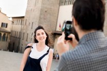 Man photographing girlfriend by Arezzo Cathedral — Stock Photo