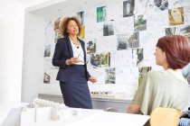 Female architect explaining to colleague — Stock Photo
