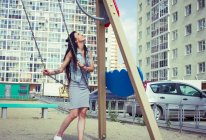 Frau auf Spielplatzschaukel — Stockfoto