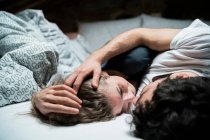 Coppia sdraiata a letto abbracciando faccia a faccia — Foto stock