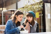 Mulheres jovens comendo comida takeaway — Fotografia de Stock
