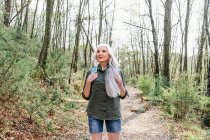 Woman with grey hair looking up from forest — Stock Photo