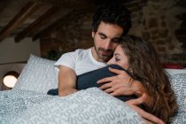 Romantic couple lying in bed hugging — Stock Photo