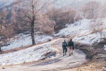 Hiking couple hiking along snowy rural road — Stock Photo