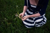 Jovem mulher colhendo flores selvagens — Fotografia de Stock