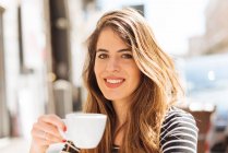 Молода жінка насолоджується кавою — стокове фото