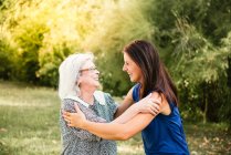 Старшая женщина обнимает внучку — стоковое фото
