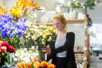 Blumenhändler wählt Blumen im Geschäft aus — Stockfoto