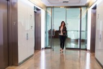 Бізнес-леді проходять через двері офісу, двері — стокове фото