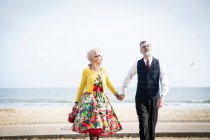 Paar hält Händchen und schlendert am Strand — Stockfoto