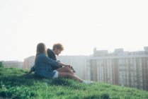 Giovane coppia seduta sul bordo erboso — Foto stock