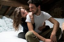 Couple sitting on bed and hugging — Stock Photo