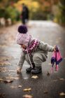 Девочка собирает осенние листья — стоковое фото