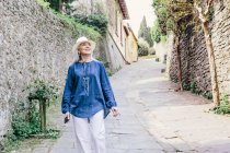 Mature woman strolling on cobbled street — Stock Photo