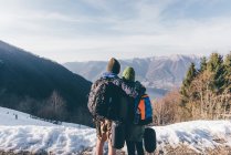 Coppia di escursionisti che si affaccia sul lago e montagne — Foto stock