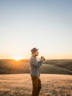 Hombre con prismáticos en colinas de pradera onduladas - foto de stock