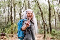 Female backpacker giving peace sign — Stock Photo