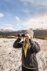 Woman looking through binoculars — Stock Photo