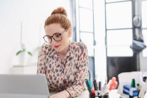 Женщина в офисе с помощью компьютера — стоковое фото
