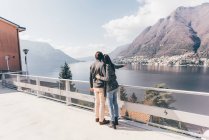 Couple pointing out toward lake — Stock Photo