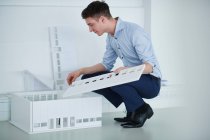 Architetto in ufficio guardando al modello architettonico — Foto stock