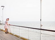 Paar schaut von Seebrücke aus — Stockfoto