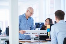 Colleagues in office looking at architectural model — Stock Photo