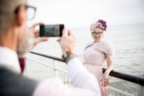 Man taking photograph of woman on pier — Stock Photo