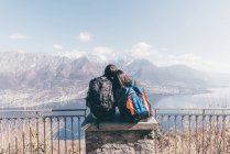 Coppia seduta sul muro della terrazza sul lago di montagna — Foto stock