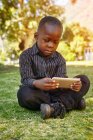 Boy playing game on cellular phone — Stock Photo