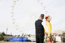 Casal apontando para a roda gigante — Fotografia de Stock