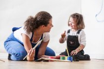 Mother and daughter playing with paint — Stock Photo