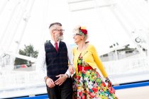 Couple strolling in front of ferris wheel — Stock Photo