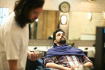 Friseur rasiert Kunden den Bart — Stockfoto