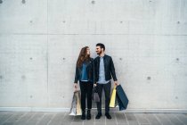 Couple standing with shopping bags — Stock Photo