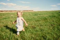 Bambino femmina che corre in campo — Foto stock
