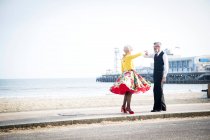 Пара, держащаяся за руки и танцующая на пляже — стоковое фото