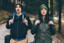 Coppia di escursionisti che indossa cappelli in maglia nella foresta — Foto stock