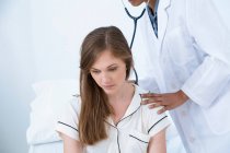Arzt untersucht Patientin mit Stethoskop — Stockfoto