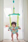 Baby girl staring from baby bouncer — Stock Photo