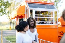 Two female friends at entrance of funfair — Stock Photo