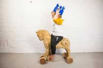 Criança masculina sentada no cavalo de brinquedo — Fotografia de Stock