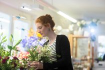 Blumenhändler wählt Blumen im Geschäft aus — Stockfoto
