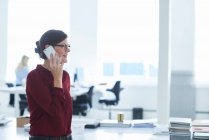 Woman in office making telephone call — Stock Photo