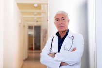 Doctor with arms folded looking at camera — Stock Photo