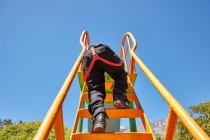 Хлопчик піднімається слайдом на дитячому майданчику — стокове фото