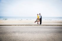 Пара, держащаяся за руки лицом к лицу на пляже — стоковое фото