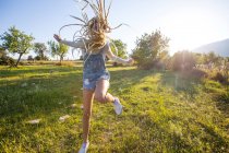 Mulher pulando de alegria no campo — Fotografia de Stock